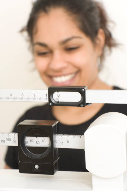 istock woman on weight scale 172690158