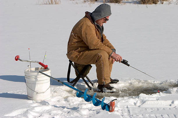 Fishing Through the Ice "Winter fishing through the ice on a pond near Sidney,Indiana U.S.A." man ice fishing stock pictures, royalty-free photos & images