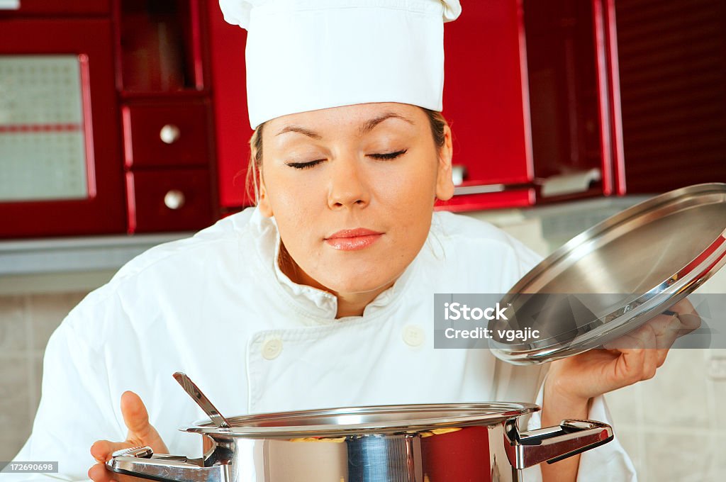 Chef tasting food aroma Closeup of young attractive female chef smelling delicious food just prepared Activity Stock Photo