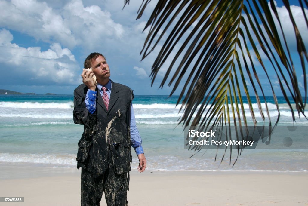 Frustrated Castaway Businessman Stands on Hold the Phone Castaway businessman stands on hold on his shell phone with an exasperated look Accidents and Disasters Stock Photo