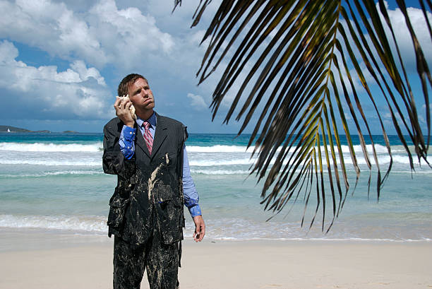frustrado náufrago empresário está em espera telefone - stranded beached beach businessman imagens e fotografias de stock