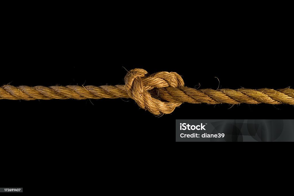 knot A rope tied in a knot on a black background. Can be used landscape or portrait. Black Background Stock Photo