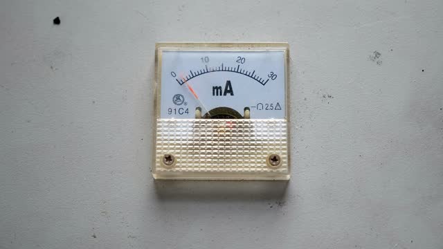 Close-up of a voltmeter at the factory on a white wall. Industrial voltmeter.