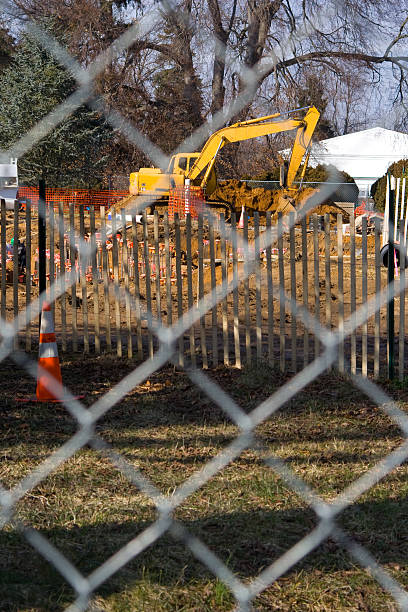 construction equipment on a jobsite a piece of construction equipment on a construction jobsite wood and wire fence designs pictures stock pictures, royalty-free photos & images