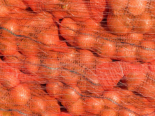 zwiebeln in rotes geflecht - onion bag netting vegetable stock-fotos und bilder