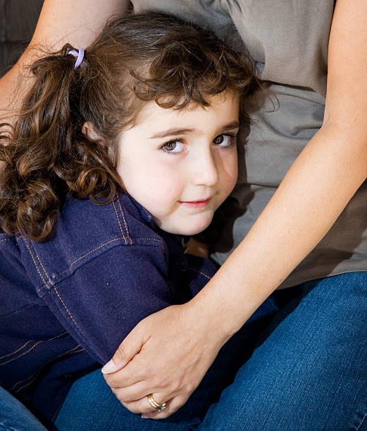 Timido bambina con le braccia della madre - foto stock