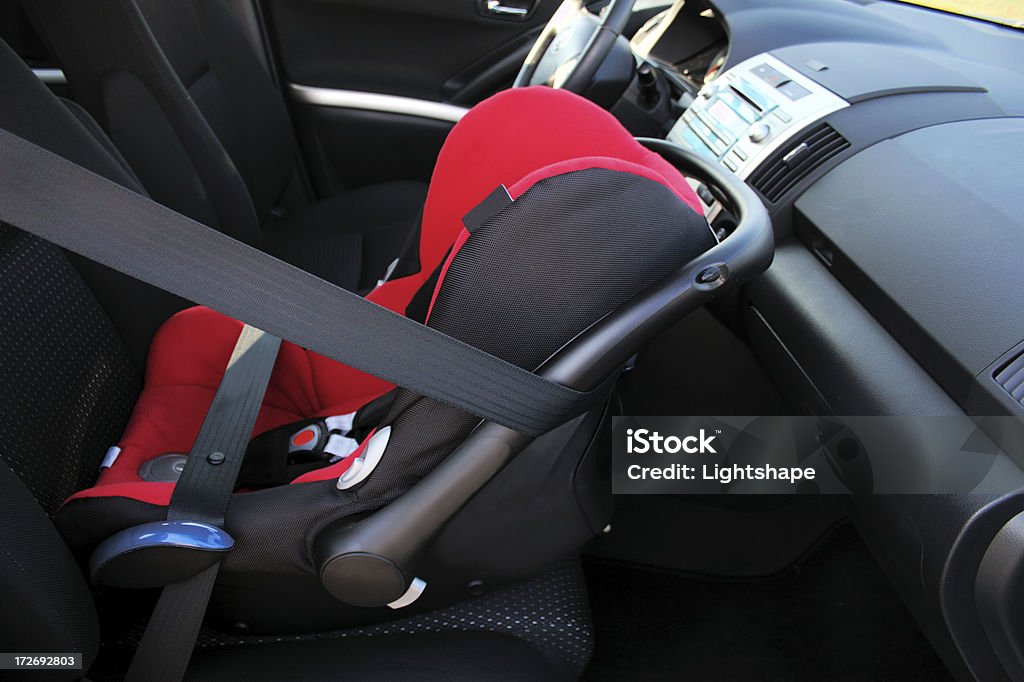 Attention: Airbag ! Child's safety seat placed on the passenger front seat. Please make sure to turn off the airbag when placing the safety seat there. Baby - Human Age Stock Photo