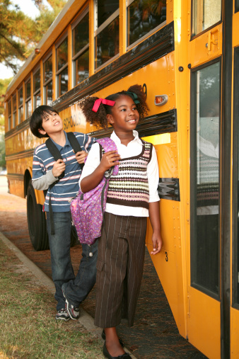 Children waiting to get on a schoolbus.  Focus is on the girl. Please view all images of this
