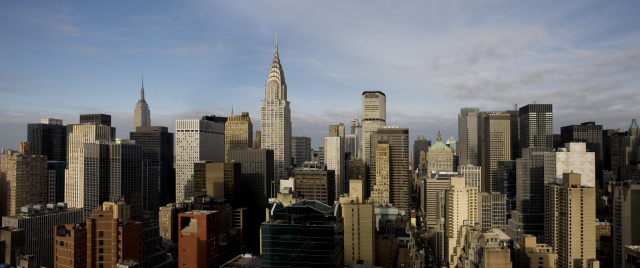 A panoramic view of the New York City skyline featuring the Chrysler Building and the Empire State building.