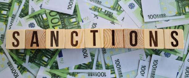 istock Sanction text on cubes on euro banknotes. EU economic sanctions 1726947577