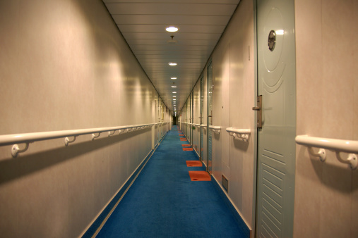 Corridor perspective of a big classical cruise ship. All cabins are on right side. Normal lightning.