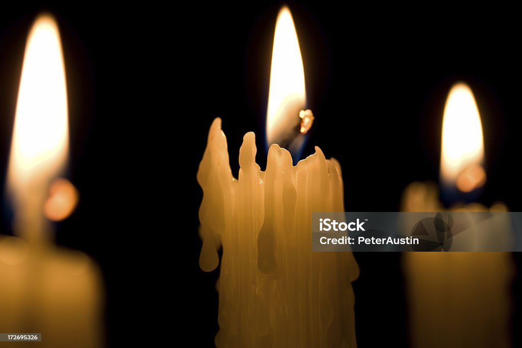 Three Candles on black Selective focus on centre candle casing. Backgrounds Stock Photo