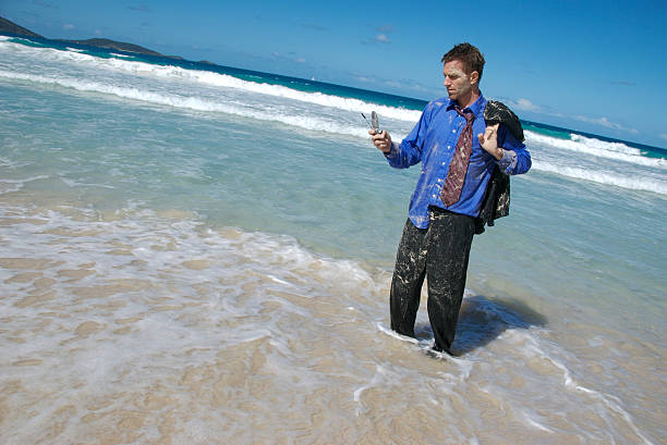 cordas viajando homem de negócios fazendo urgente efectuar chamadas móveis - stranded beached beach businessman imagens e fotografias de stock