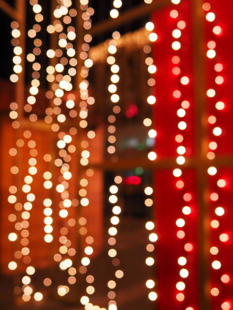 Bokeh on Christmas night. Beautiful round bokeh highlights. Red, yellow, gold, white colors in the dark. Festive background for New Year Merry Christmas. Blurred defocus. Decoration of city streets stock photo