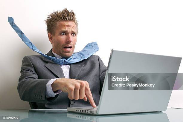 Stressed Young Businessman Using Laptop Computer At Desk Stock Photo - Download Image Now