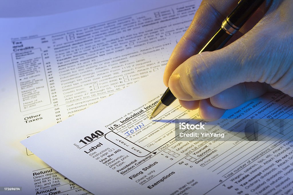 Filling out U S Income Tax Hz "Subject: Filling out the U.S. Income Tax Return, Form 1040." Tax Stock Photo