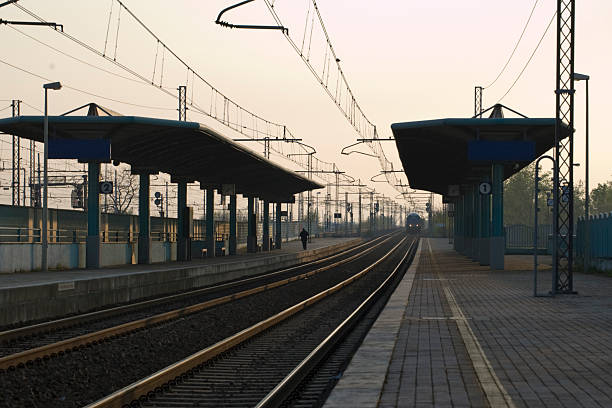 Lone man waiting for a train in an empty Italian station