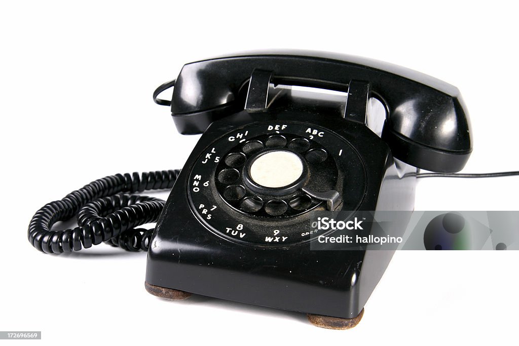 Black Rotary Dial Phone Retro dusty black rotary dial phone isolated on a white background. 1950-1959 Stock Photo