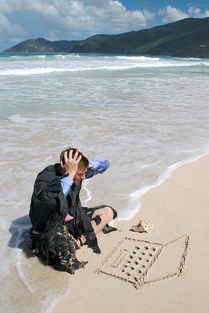 Castaway Businessman Has Problems with Laptop Computer Castaway businessman holds his hands to his head looking at his sand laptop computer castaway stock pictures, royalty-free photos & images