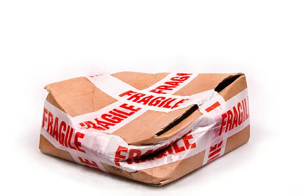Photo of A smashed box with fragile tape all around it