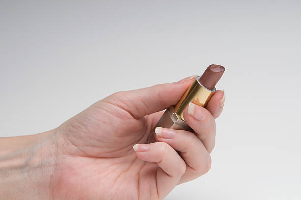 lipstick in womans hand stock photo