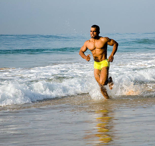 athlete jogging in the surf stock photo