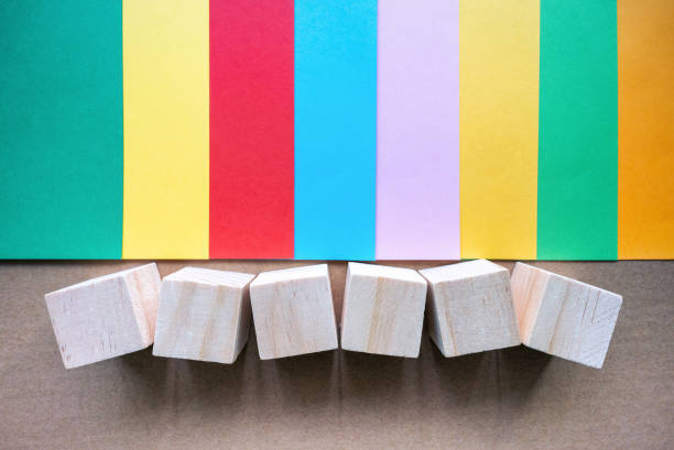 Toy block and blank multi colored paper background.