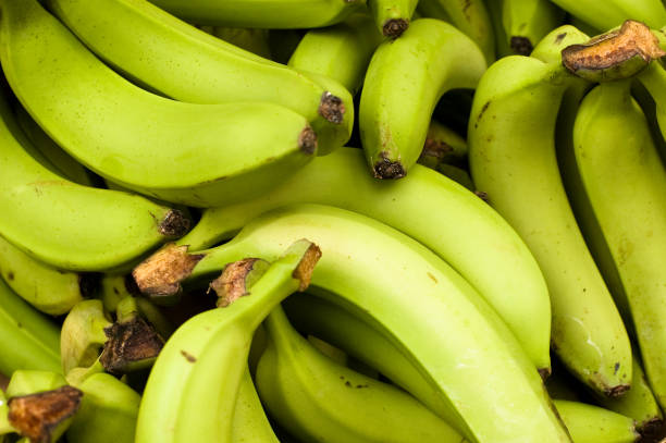 зеленый бананов - banana bunch yellow healthy lifestyle стоковые фото и изображения