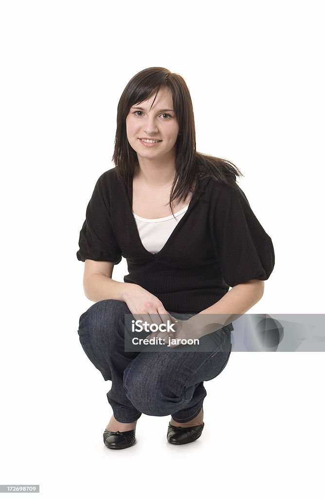 Joven atractiva mujer agachándose - Foto de stock de Agacharse libre de derechos