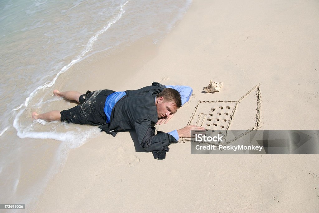 Uomo d'affari che dorme sul portatile sdraiata sulla spiaggia di sabbia - Foto stock royalty-free di Humour