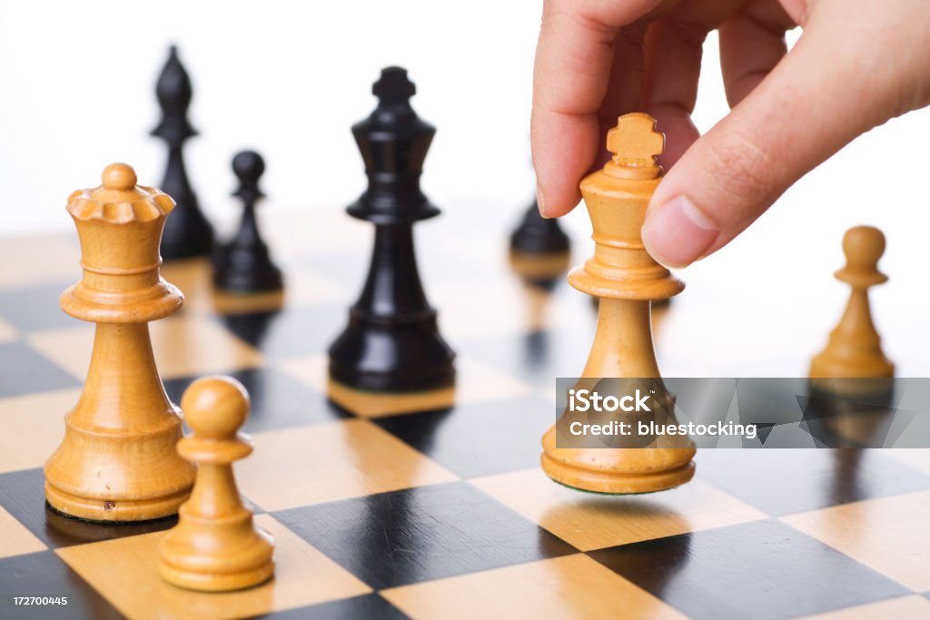 Chess A hand moving the king in a chess game. Achievement Stock Photo