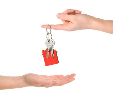 Handing over two silver keys with keyring and house shaped tag (clipping paths included)