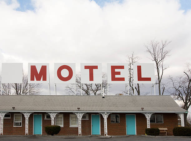 Retro Red Lettered Motel Sign on top of building retro style painted Motel sign above old roadside Motel. motel stock pictures, royalty-free photos & images