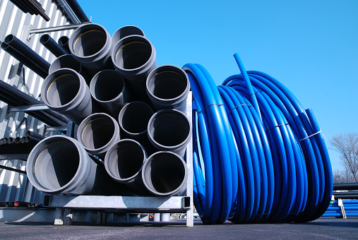 Gray and blue PVC pipes stacked at hard ware store. Please see similar pictures: 