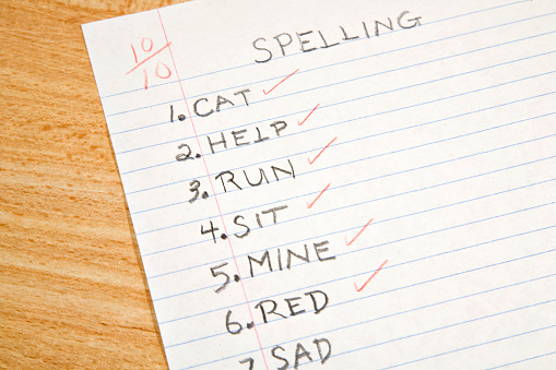 Spelling test with list of words in student handwriting.  Red pencil check marks with a mark assigned.