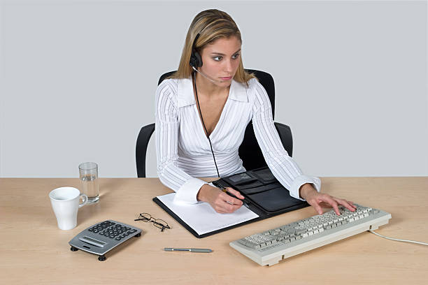 woman working in the office "Beautiful female call center operator with headset like customer service on work at keyboard, isolated on white background" jacraa2007 stock pictures, royalty-free photos & images