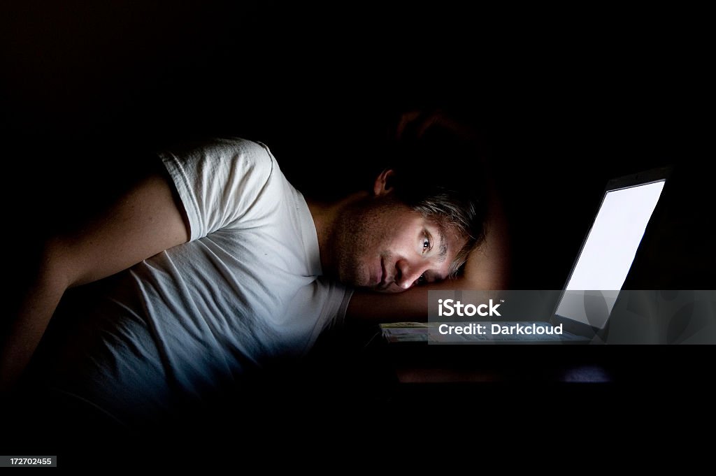 Man on computer A man looks depressed by a computer late night. Adult Stock Photo