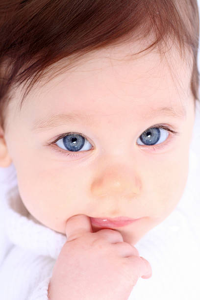 baby with finger in mouth stock photo