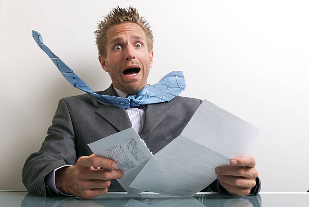 Office Worker Businessman Opening Letter with Expression of Stress Office worker businessman opening letter at his desk with expression of stress drudgery photos stock pictures, royalty-free photos & images