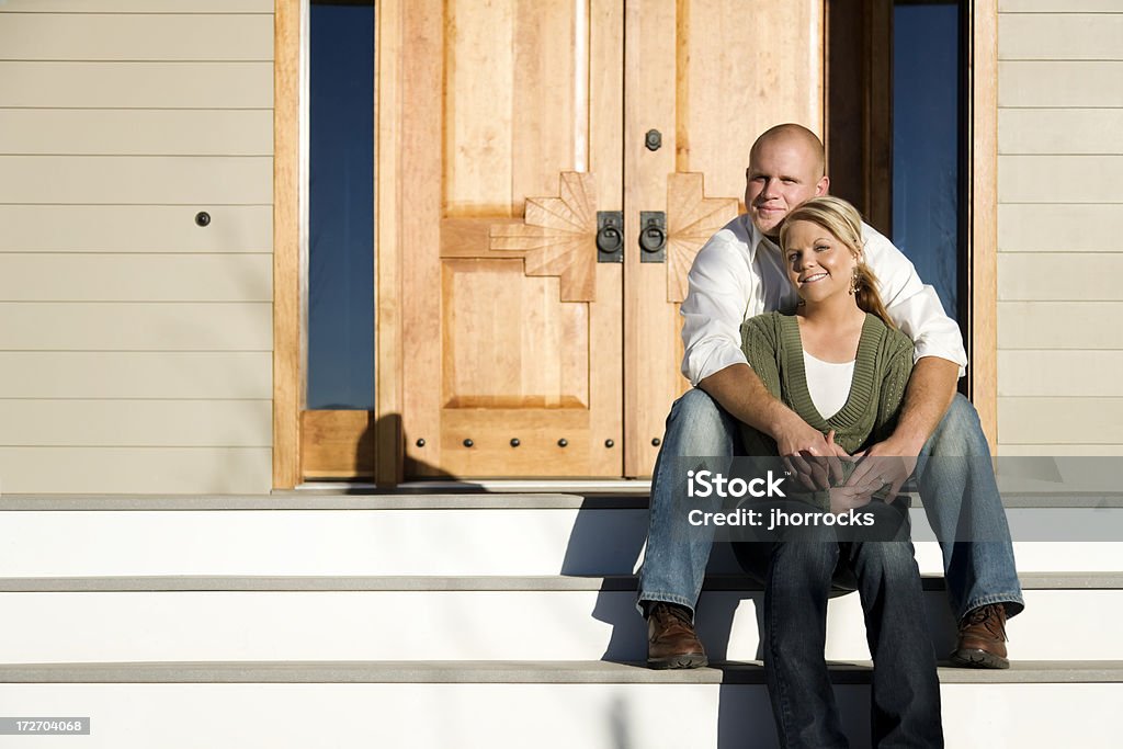 Casal feliz sentado em frente de Step - Foto de stock de Abraçar royalty-free