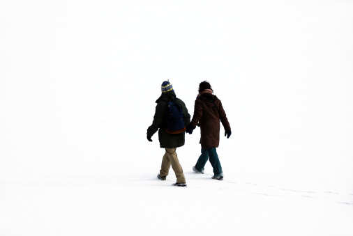 romantic couple walking on the frozen lake and snow