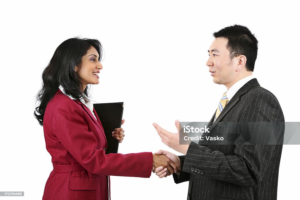 Business Handshake An Indian woman shaking an Asian man's hand. White Background Stock Photo