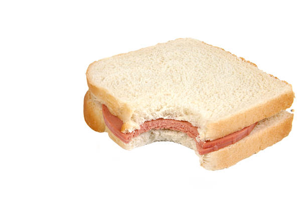 Bologna Sandwich with Bite A bologna sandwich with a bite missing on a white background. baloney stock pictures, royalty-free photos & images