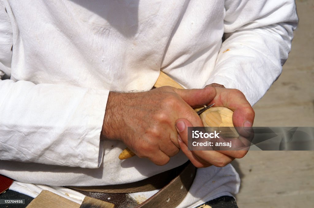 Carwer with wooden spoon Craftsman carving a wooden spoon on a medieval market. (entertainment on the Ljubljana castle) Selective focus on the spoon. (digital camera) Art Stock Photo