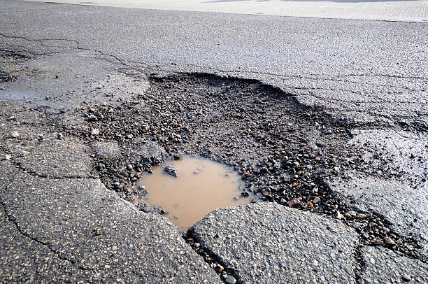 istock Large pot hole in the road. 172705969