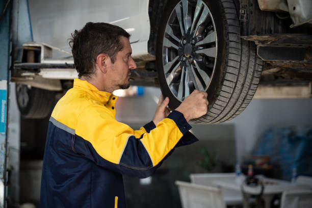 istock Hardworking mechanic changing car wheel in auto repair workshop. Oxus 1727071855