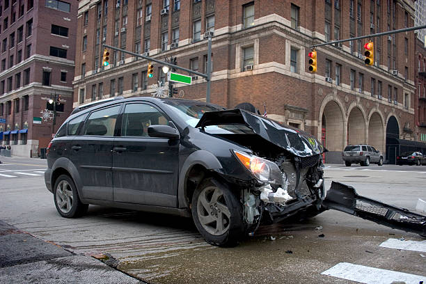 Black car with a smashed front in an intersection stock photo