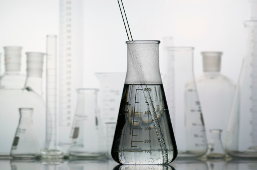 An full Erlenmeyer flask with other laboratory glass in the background.