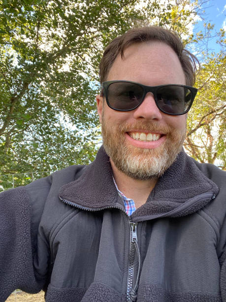 Selfie of a middle-aged man sitting under trees