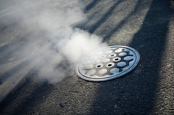 Smoking manhole cover in  new York City Urban Scene of a smoking manhole cover in Manhattan manhole stock pictures, royalty-free photos & images